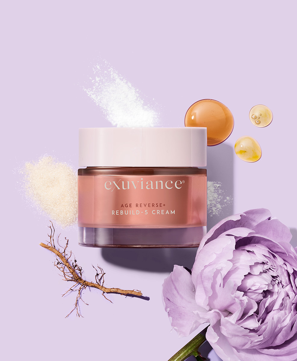 Produkten Age Reverse Rebuild-5 Cream med ingredienser runt sig. Bland annat en stor, lila pion.